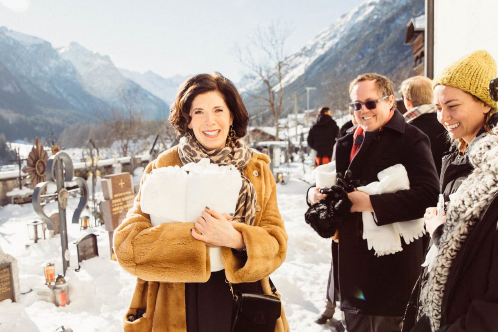 Gäste lachen gemeinsam im Schnee nach der Trauung